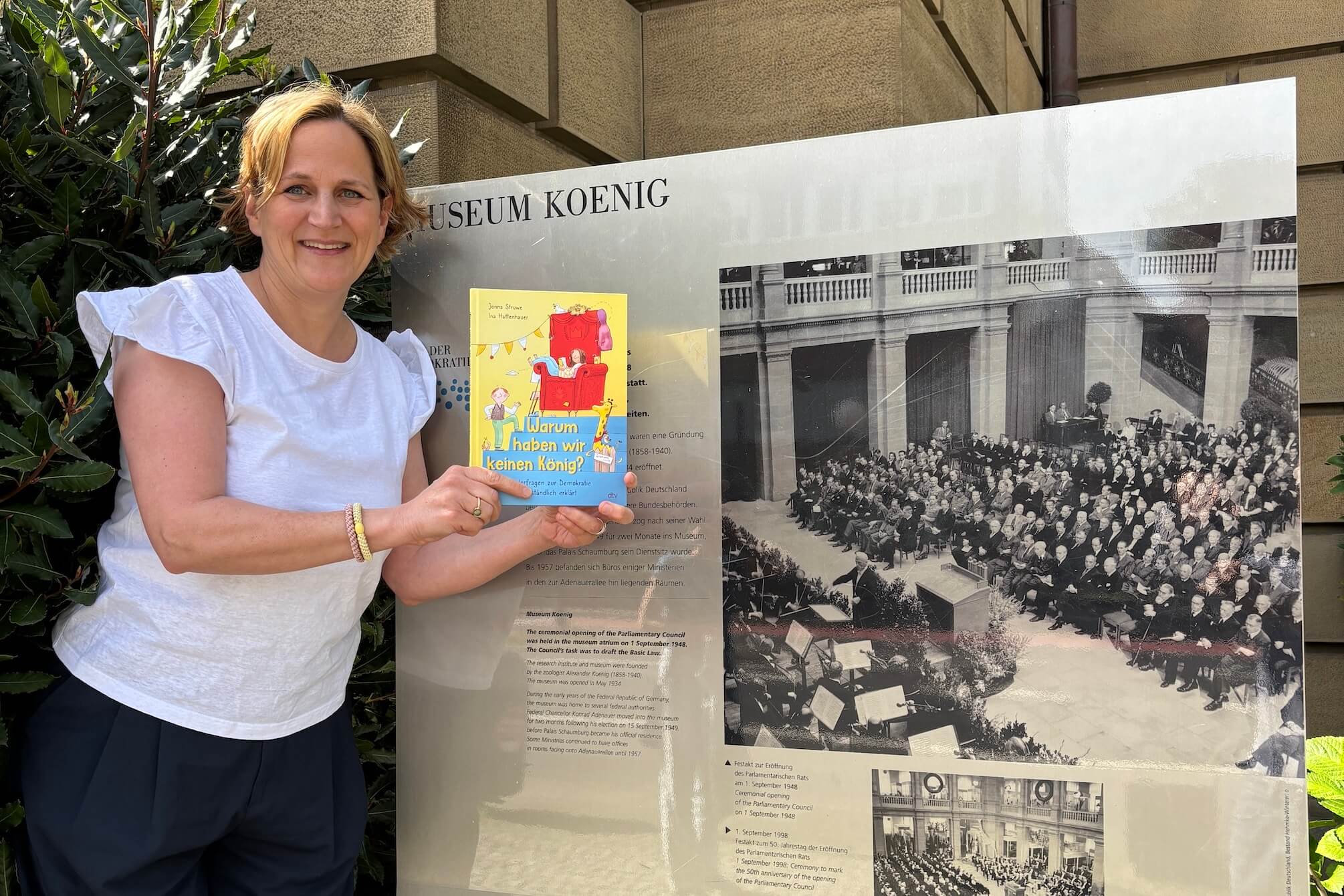 Autorin Jonna Struwe vor dem Museum Koenig in Bonn mit dem Cover von "Warum haben wir keinen König?"
